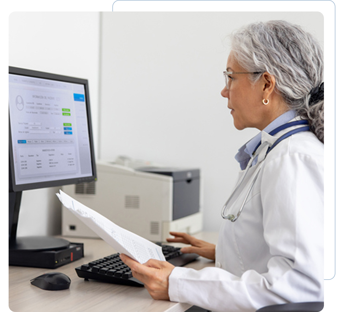 Doctor reviewing documents on computer screen.