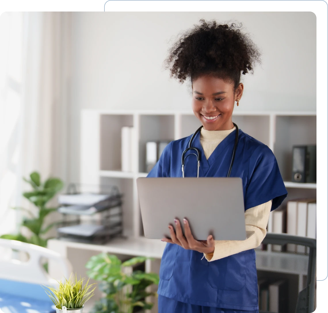 Smiling nurse using a laptop in office.